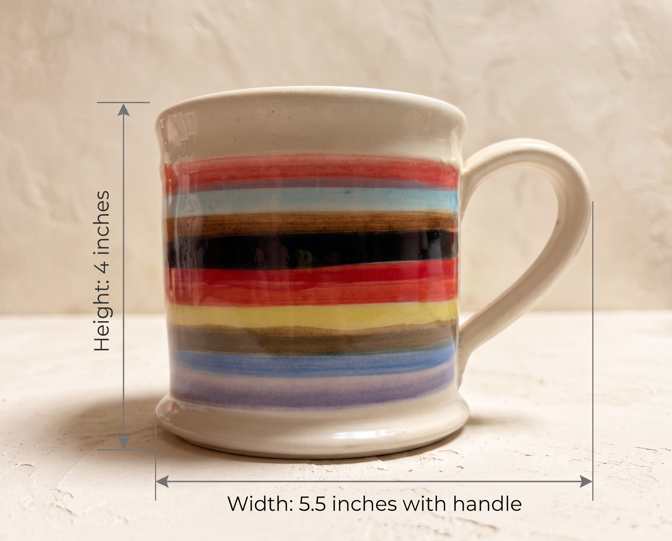A ceramic mug with a multicolor horizontal stripe pattern, shown with dimension lines indicating a height of 4 inches and a width of 5.5 inches with the handle.