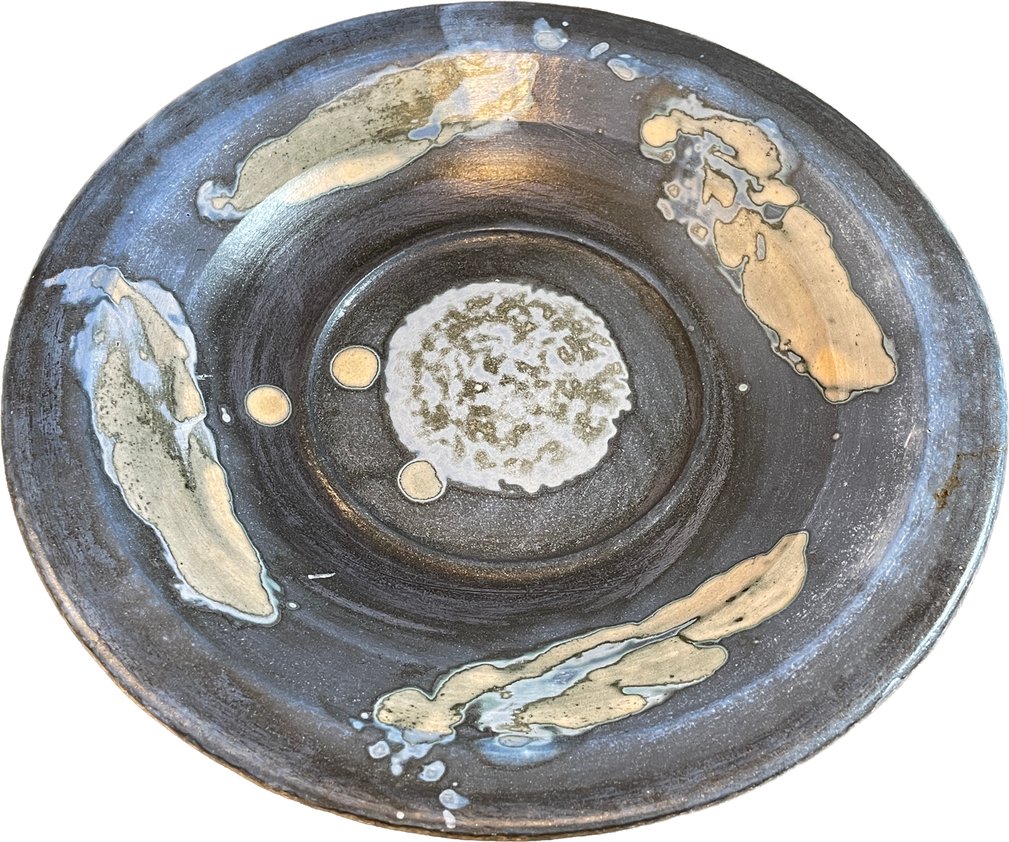 A round handmade ceramic plate with a dark charcoal gray glaze, featuring abstract hand-painted gold and beige brushstrokes and a textured white and green center.