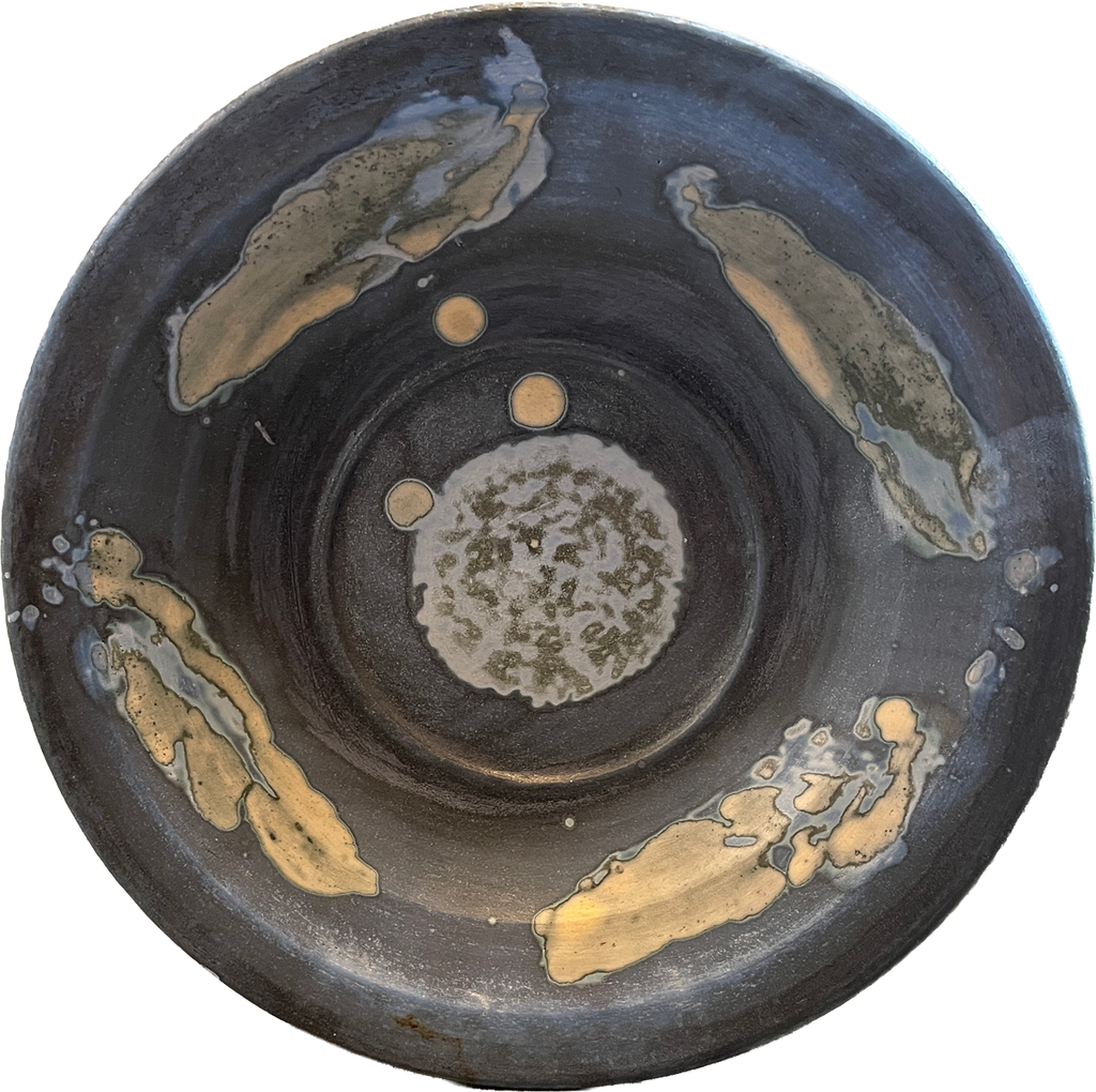 A round ceramic bowl with a dark charcoal gray exterior and a textured, speckled off-white interior, decorated with four irregular metallic gold leaf accents on the outer surface.
